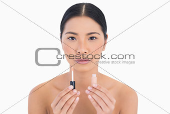 Beautiful model holding lip gloss