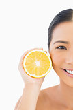 Half face of smiling pretty woman with orange