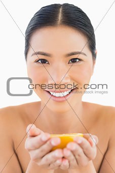 Smiling pretty woman holding orange