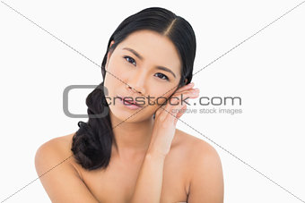 Sensual dark haired model touching her cheek