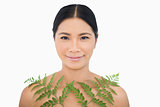 Sensual dark haired model posing with fern