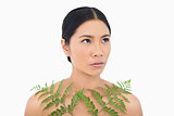 Thoughtful sensual dark haired model posing with fern