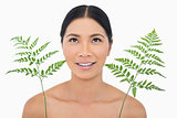 Cheerful sensual dark haired model with fern looking up