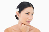 Pensive sensual model wearing white flower in her hair