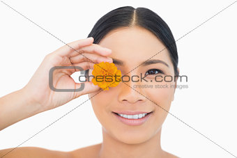 Sensual black haired model holding orange flower
