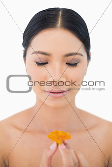 Natural black haired model holding orange flower