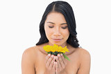 Natural black haired model smelling sunflower