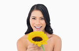 Happy natural model holding sunflower in her hand
