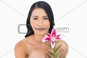 Natural black haired model posing with lily