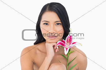 Natural model with lily touching her chin