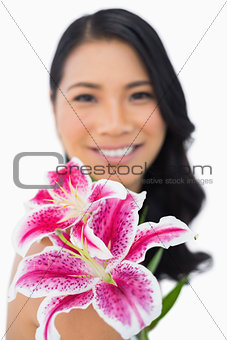 Cheerful natural brown haired model posing with lily