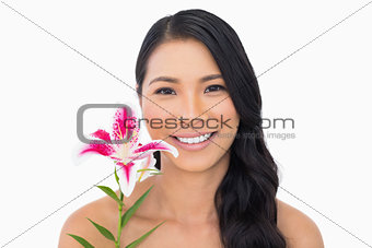 Smiling natural brown haired model holding lily