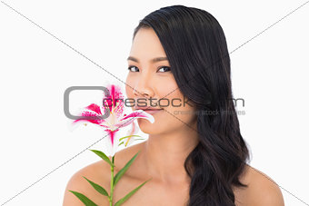 Peaceful natural brown haired model smelling lily