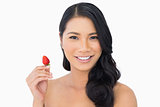 Natural brown haired model holding strawberry