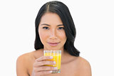 Sensual nude model holding orange juice