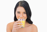 Sensual nude model drinking orange juice