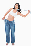 Sexy woman wearing too big pants and strangling herself with measuring tape