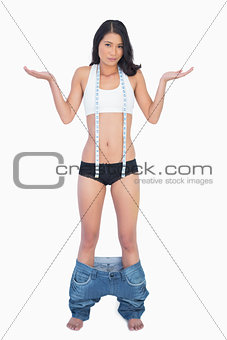 Surprised woman wearing jeans falling down because shes lost weight