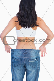 Back of woman holding her too big jeans