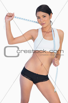 Self confident slim woman holding her measuring tape