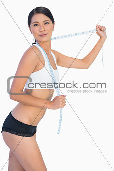 Self confident slim woman playing with her measuring tape