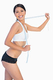 Smiling slim woman playing with her measuring tape
