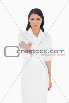 Elegant dark haired model with classy dress holding out her hand