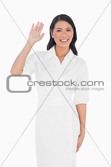 Smiling dark haired model with classy dress greeting