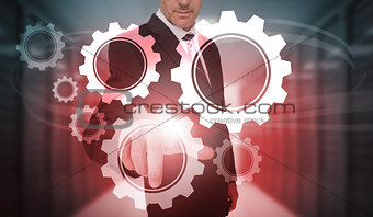 Businessman selecting futuristic cog and wheel interface