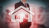 Businessman selecting futuristic house icon on touchscreen