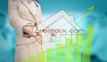 Businesswoman touching futuristic house interface with green bar chart