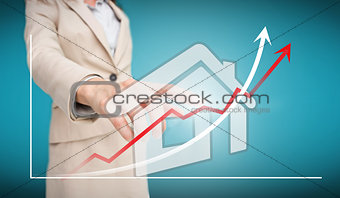 Businesswoman touching futuristic house interface with graph