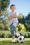 Young boy posing with football with arms crossed