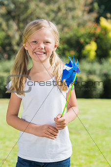 Blonde girl smiling and holding pinwheel