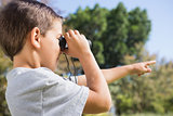 Boy looking through binoculars and pointing