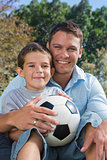 Cheerful dad and son with football