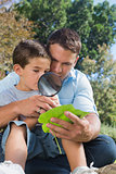 Dad and son inspecting leaf with a magnifying glass