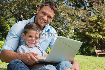 Smiling son and dad with a laptop