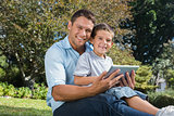 Happy dad and son with a tablet pc