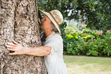 Retired woman hugging a tree