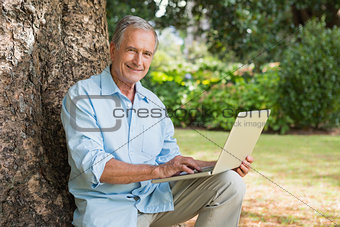 Smiling old man with a laptop