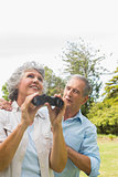 Woman holding binoculars with partner