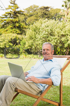 Smiling mature man using laptop