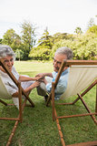 Smiling mature couple lying on sun loungers