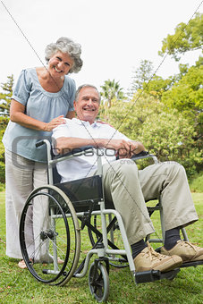 Cheeful mature man in wheelchair with partner