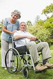 Smiling mature man in wheelchair with partner
