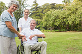 Cheerful man in a wheelchair with his nurse and wife