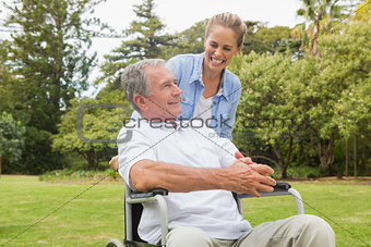 Laughing man in wheelchair and daughter talking