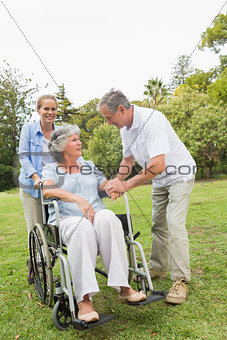 Mature woman in wheelchair with husband and daughter
