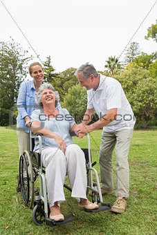 Retired woman in wheelchair with husband and daughter